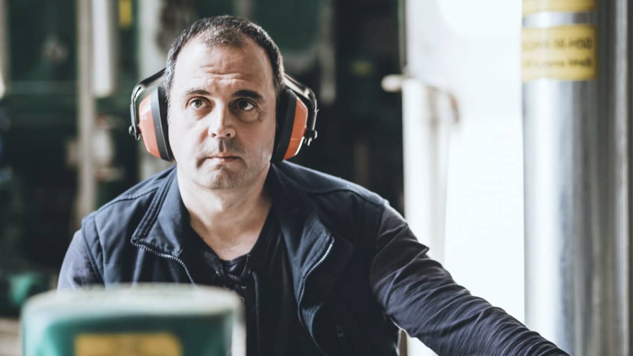Foto de un hombre con los auriculares puestos sentado en un almacén